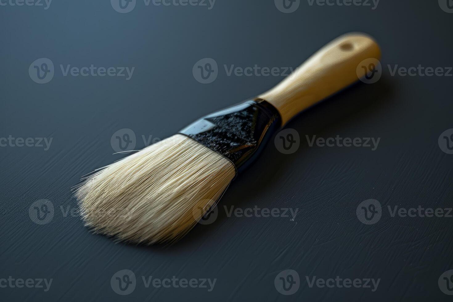 New paintbrush resting on a dark surface photo