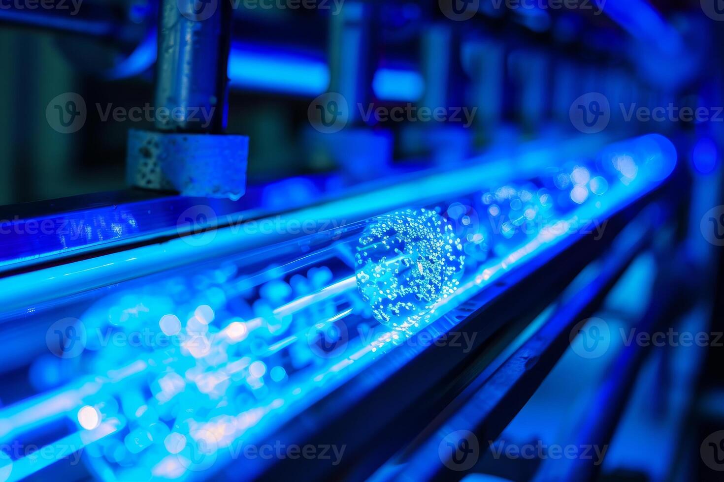Water bottles being sterilized with ultraviolet light on conveyor belt photo