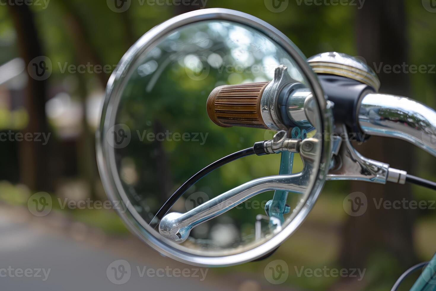 Round chrome bicycle mirror reflecting handlebars and green background photo