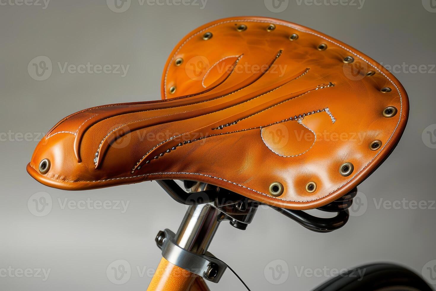 Brown leather bike saddle with visible stitching and rivets photo