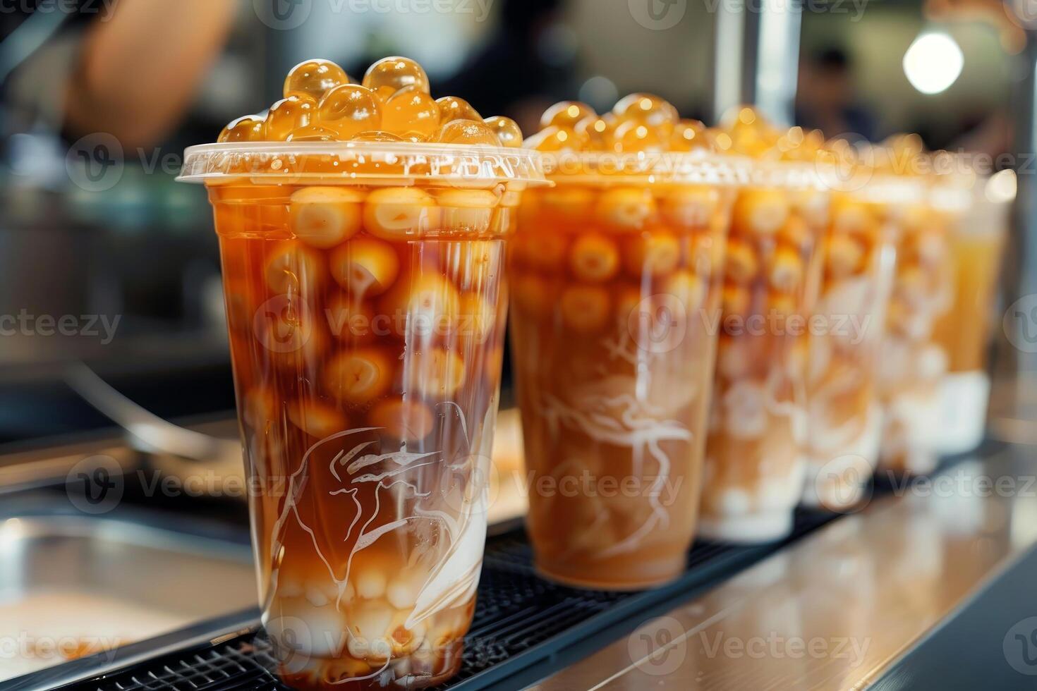 Bubble tea cups filled with tapioca pearls and tea awaiting customers in a cafe photo