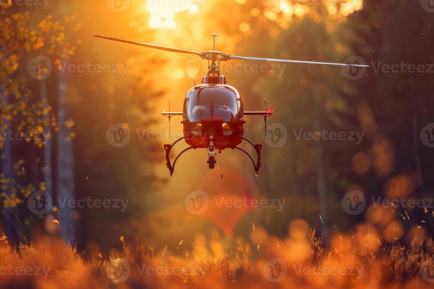 Modern helicopter flying over autumn forest at sunset photo