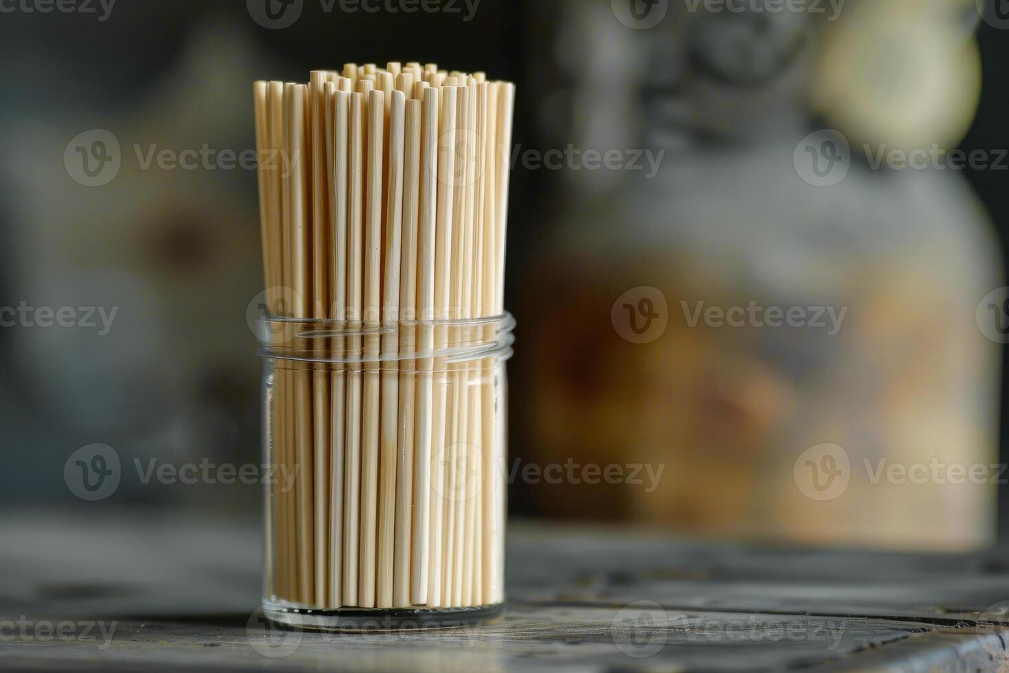 Many bamboo skewers standing upright in a glass on a table photo