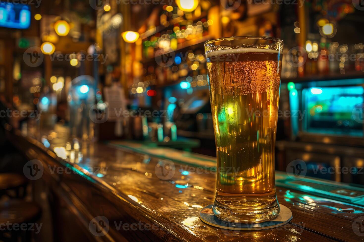 Refreshing glass of cold beer standing on a bar in a busy pub photo