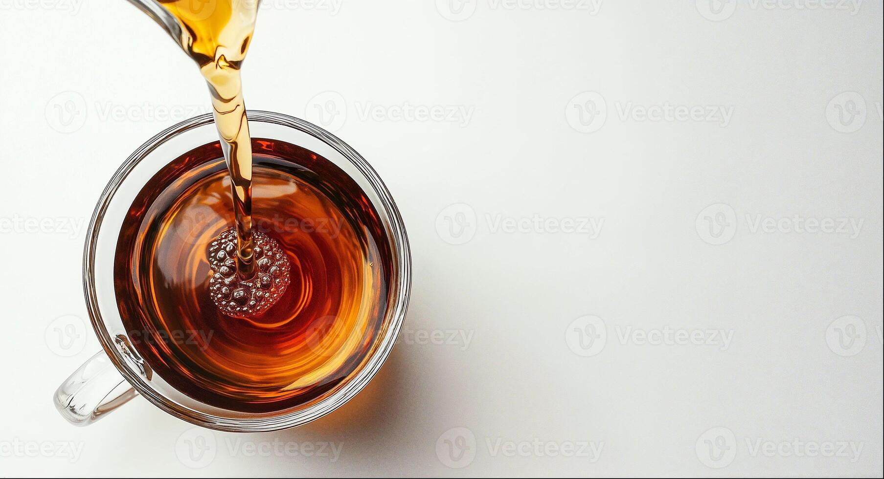Black tea is pouring into glass mug, top view, tea package design element, white background with copy space photo
