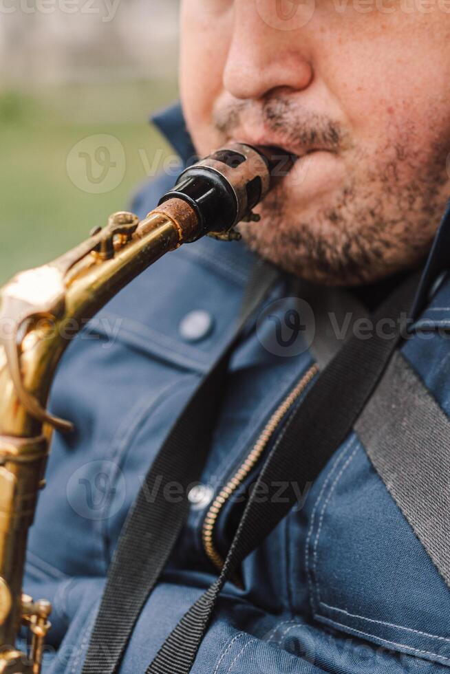 A saxophonist performs in a serene park during autumn while seated on a bench photo