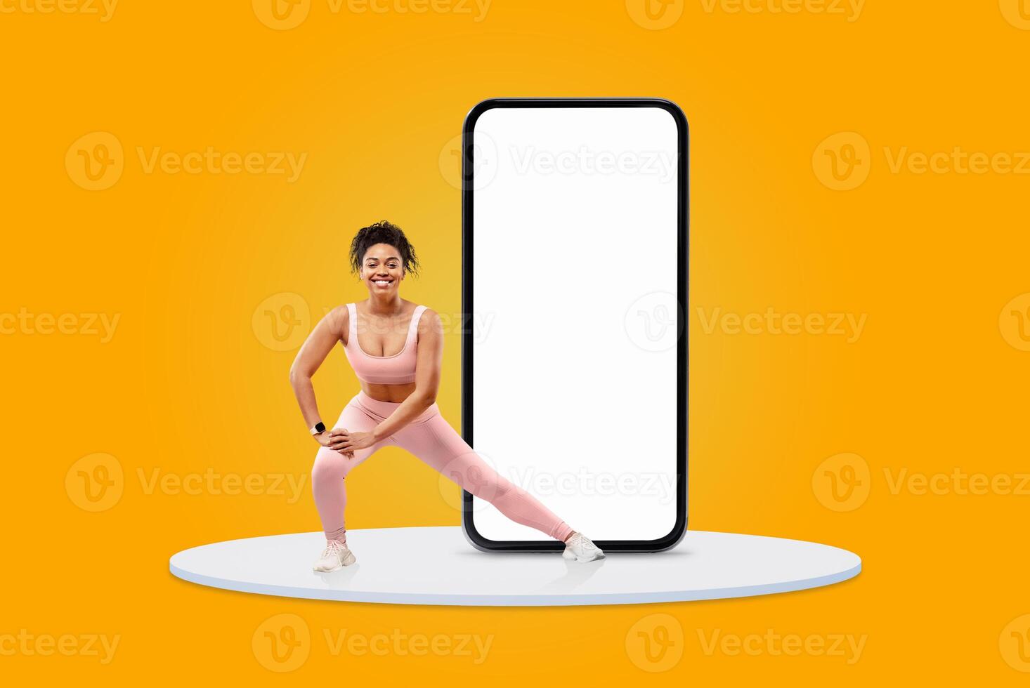 A woman in workout attire engages in a fitness routine next to a blank smartphone screen. The bright yellow background adds energy to her active stance, emphasizing her commitment to health. photo