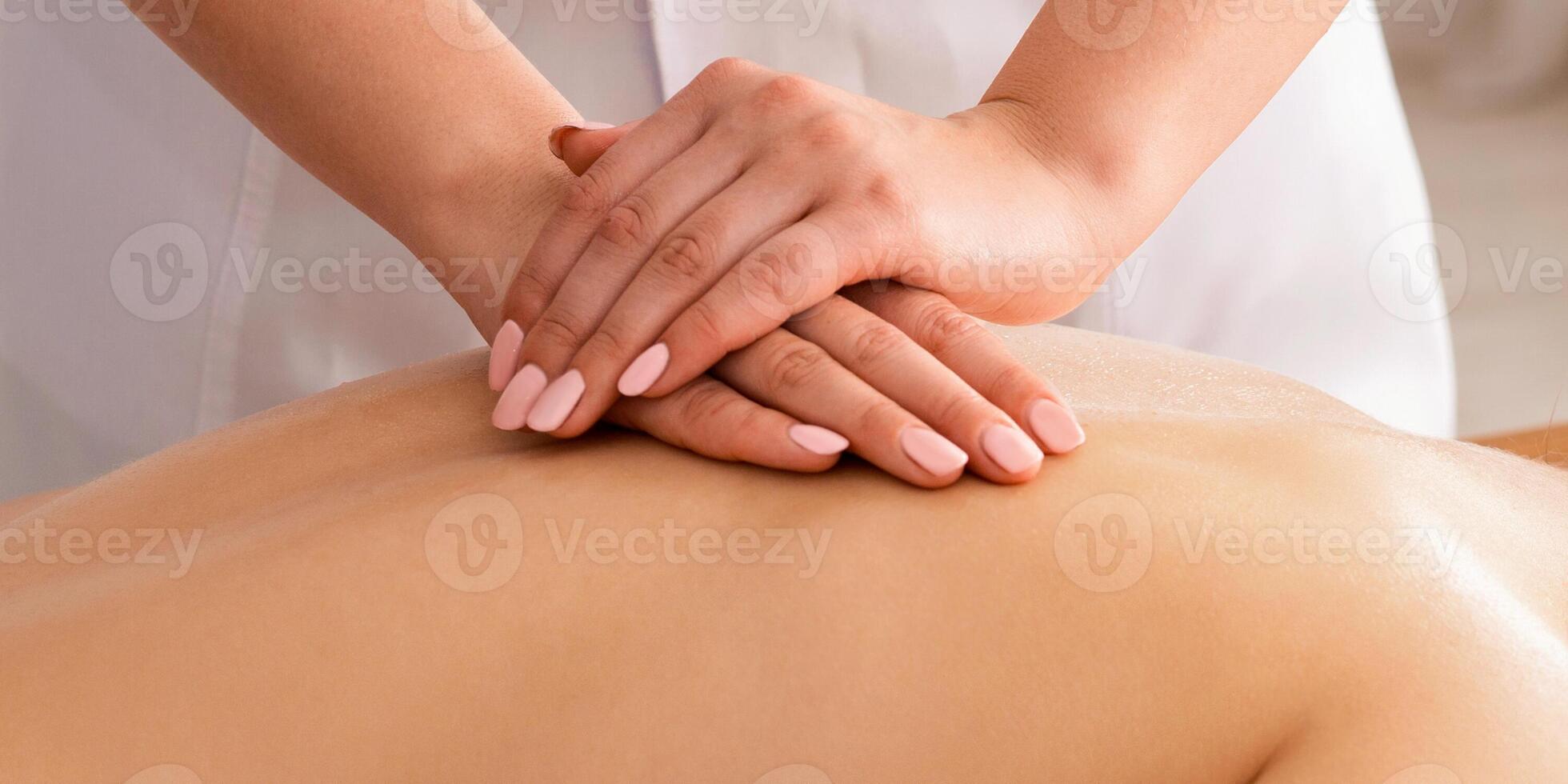 Hands make therapeutic massage for girl, lying on table in spa photo