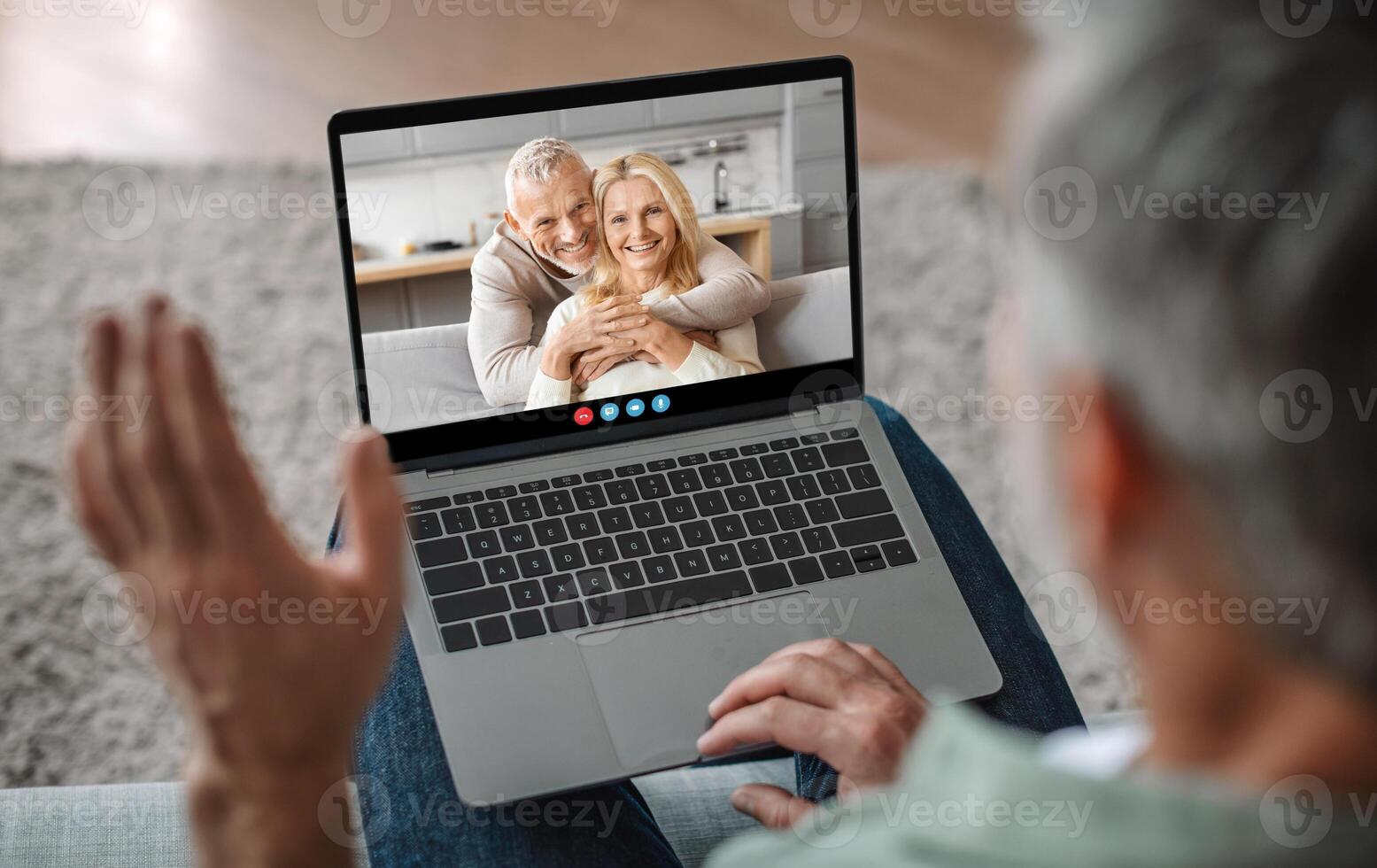 A person waves while communicating via call, engaging with a happy couple who are smiling at the screen. The setting is a cozy indoor environment, embodying warmth and connection. photo