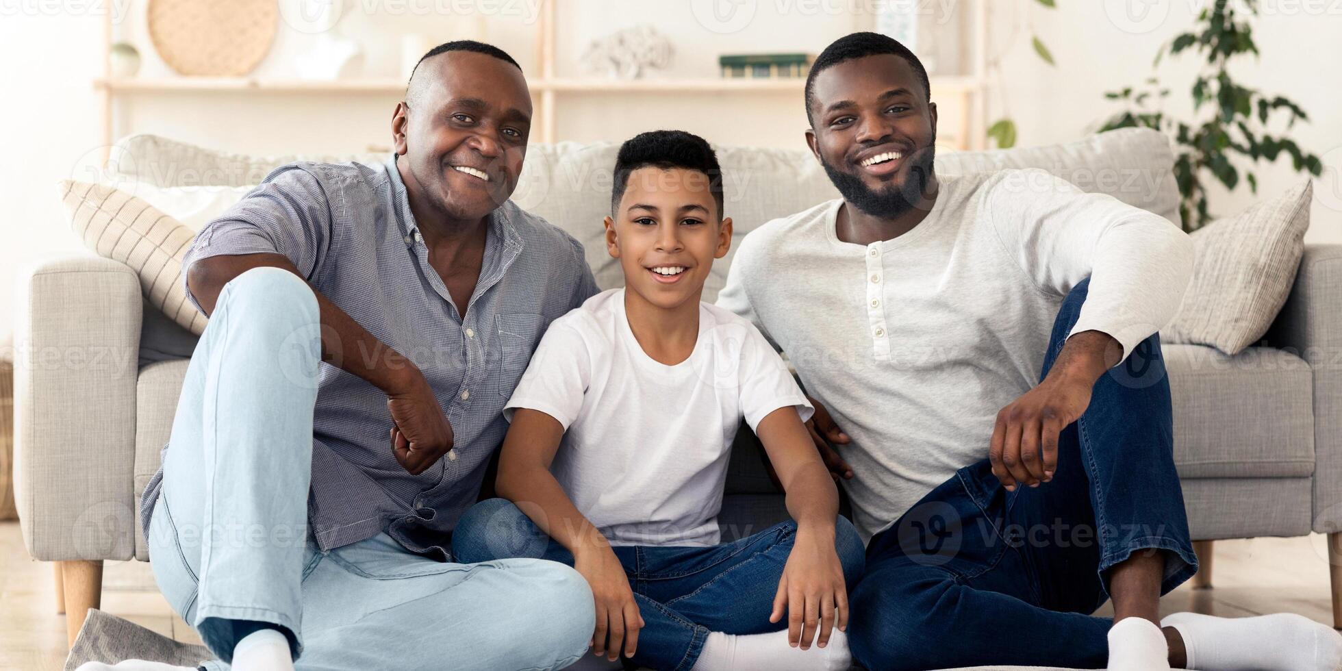 Three generation men family portrait. Happy little boy posing with his young father and senior grandfather at home, looking at camera, free space photo