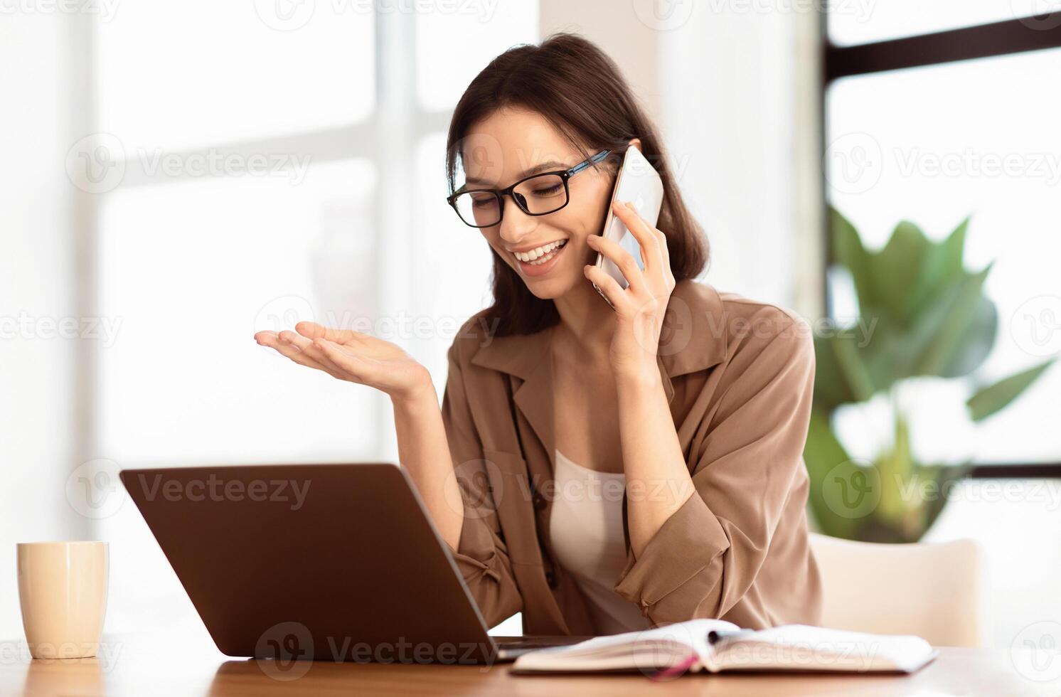 Informal Call. Happy young woman in glasses calling her friend, talking and asking about something, using laptop photo