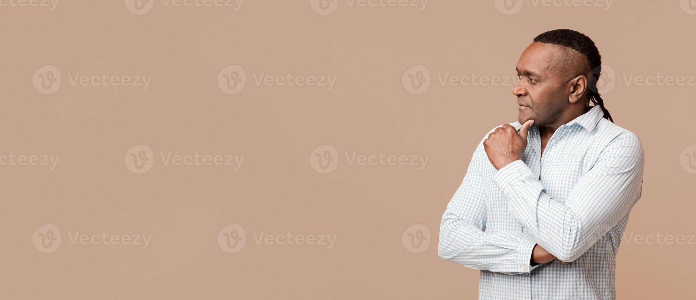 Interesting promo. Pensive mature african american man looking at empty space, orange background photo