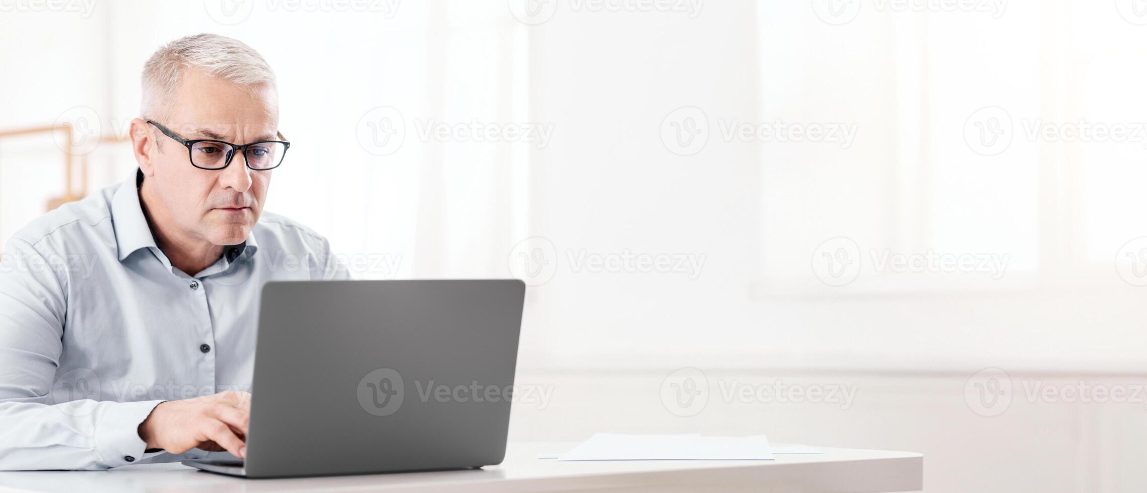 Web Surfing Concept. Focused Senior Man In Specs Using Wifi Working On Laptop, Free Space photo