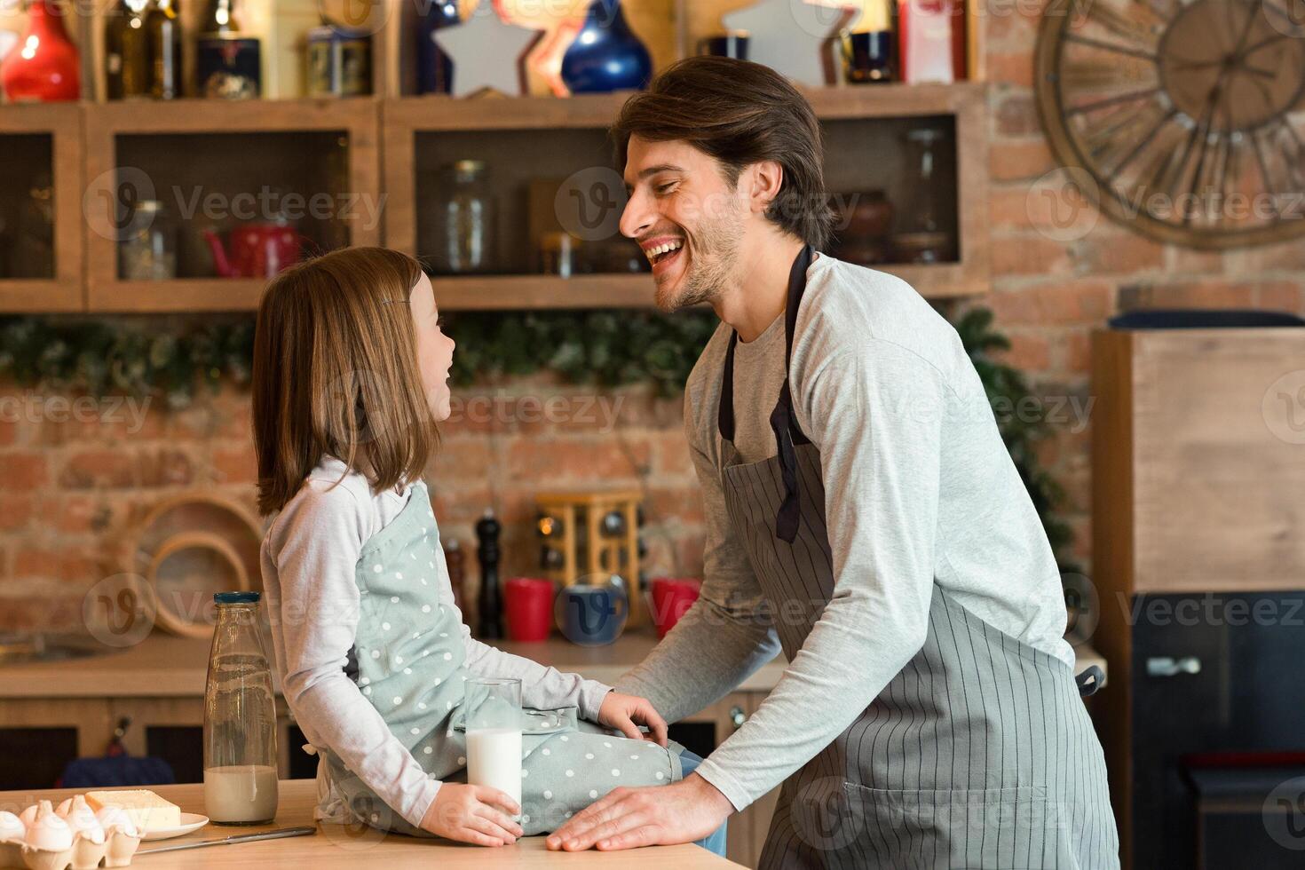 Cute Little Girl Having Fun With Dad In Kitchen While Cooking Together, Sitting On Table And Drinking Milk, Father And Daughter Making Homemade Pastry, Baking Pie And Enjoying Family Time, Free Space photo