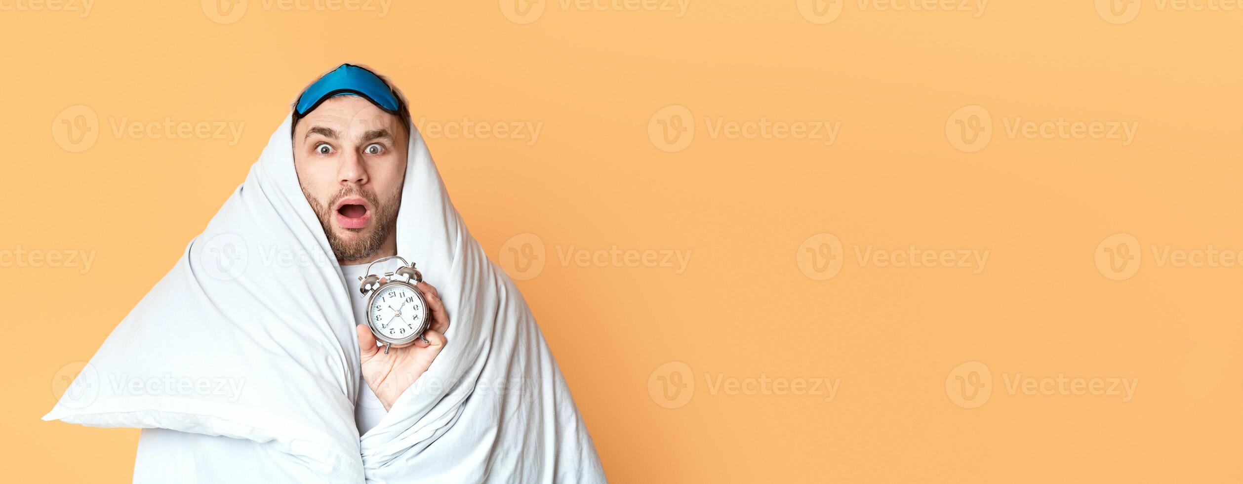 Young man does not want get up for work on yellow background photo