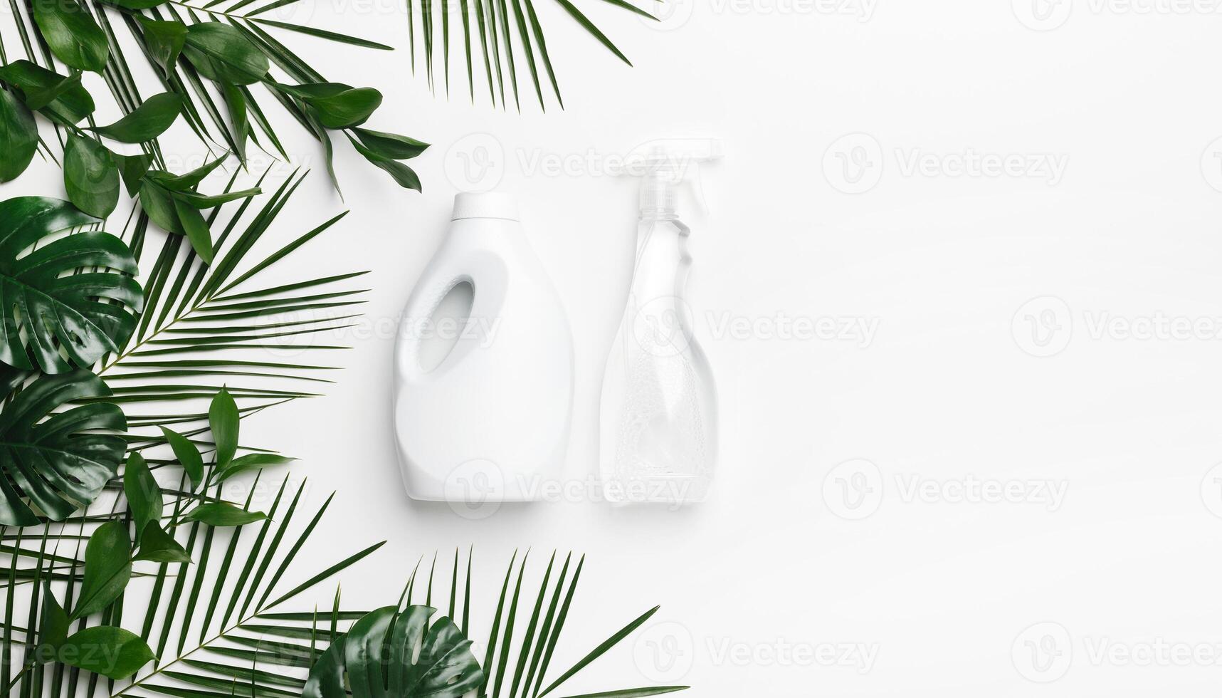 Eco cleaning detergent in white plastic bottles with green leaves on white background, copy space. Eco recycling cleaning product photo