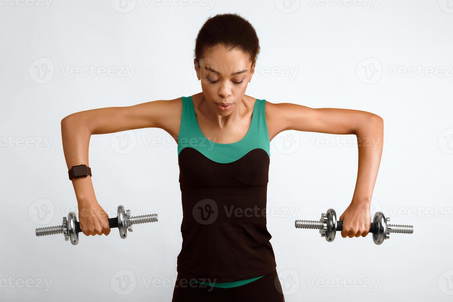 Strength Workout. Sporty Afro Woman Exercising With Dumbbells Standing Over Yellow Background. Studio Shot photo
