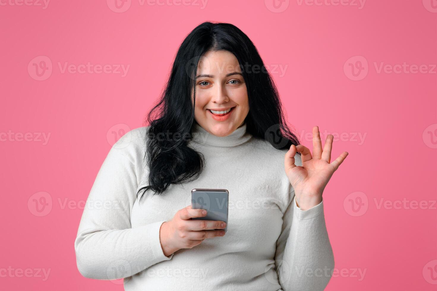 Best Dieting App. Beautiful Plus Size Model Girl Holding Smartphone And Gesturing Ok Sign, Recommending New Application, Pink Background, Copy Space photo