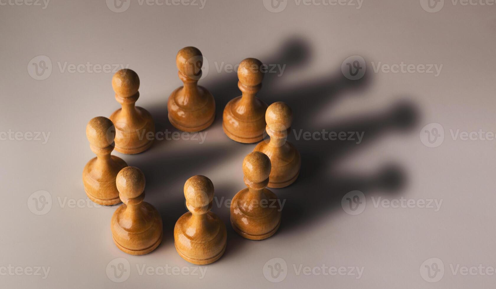 Wooden chess pawn circle with shadow shaped as crown on gray background. Teamwork, group agreement and success concept photo