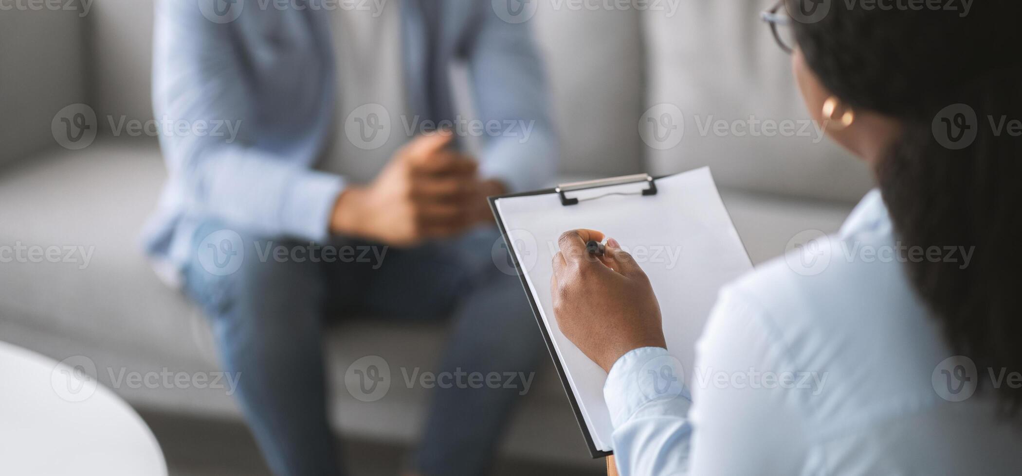 Professional psychotherapy. Female psychologist having session with young male patient at mental health clinic, selective focus. Banner design with copy space. Treatment of depression concept photo
