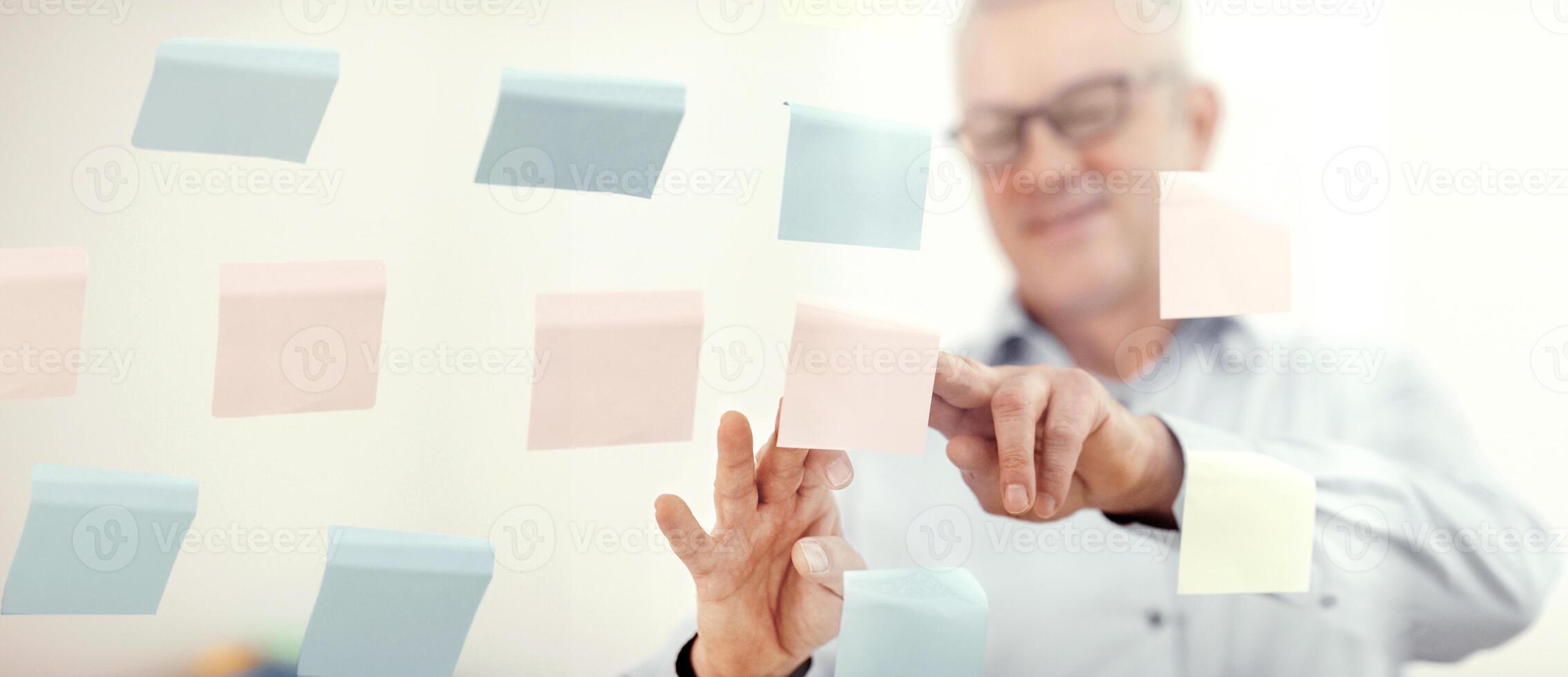 Presentation Concept. Successful middle-aged business man putting his ideas on sticky notes in conference room photo