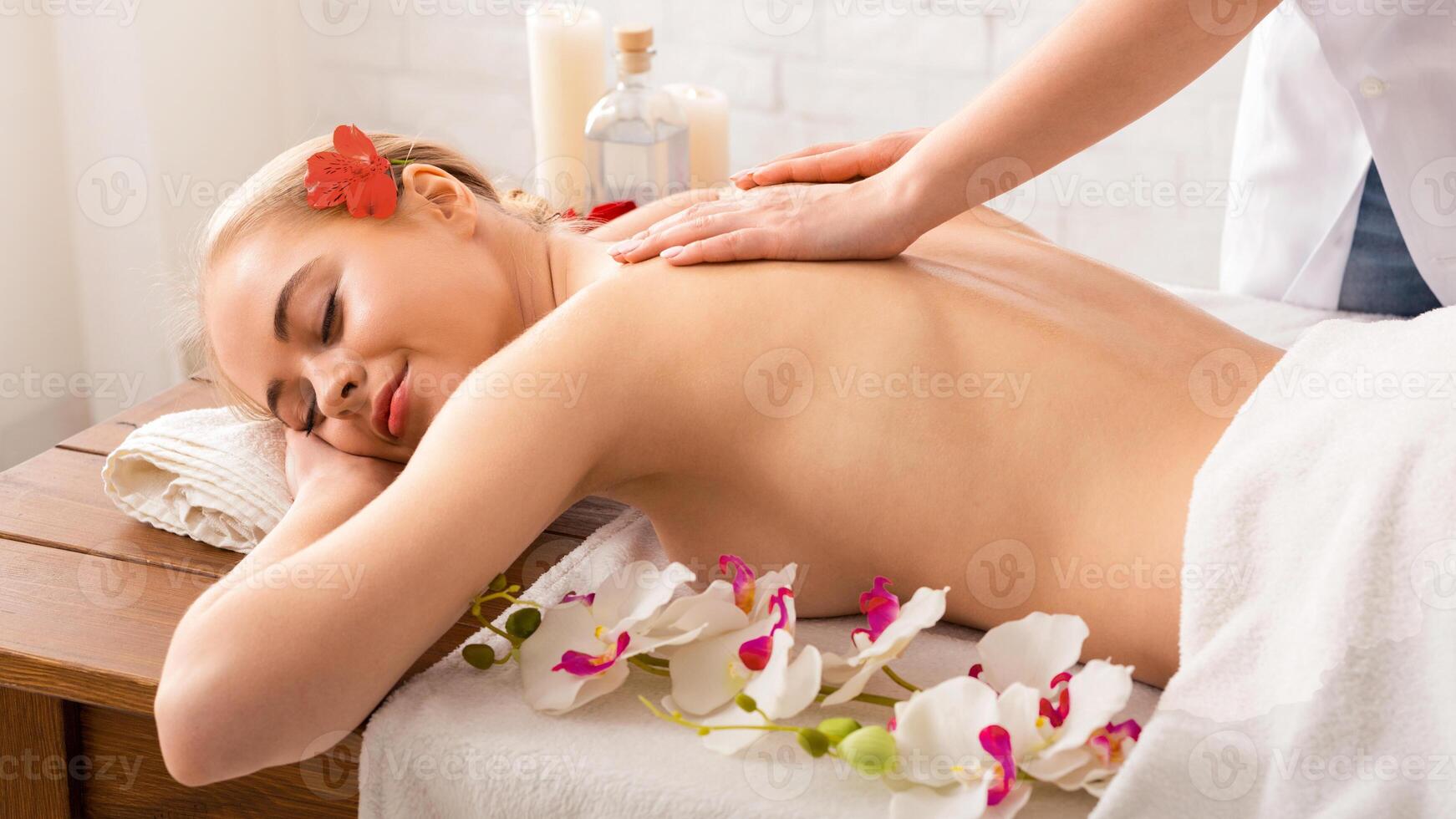Relaxing massage with oil for millennial girl in spa photo