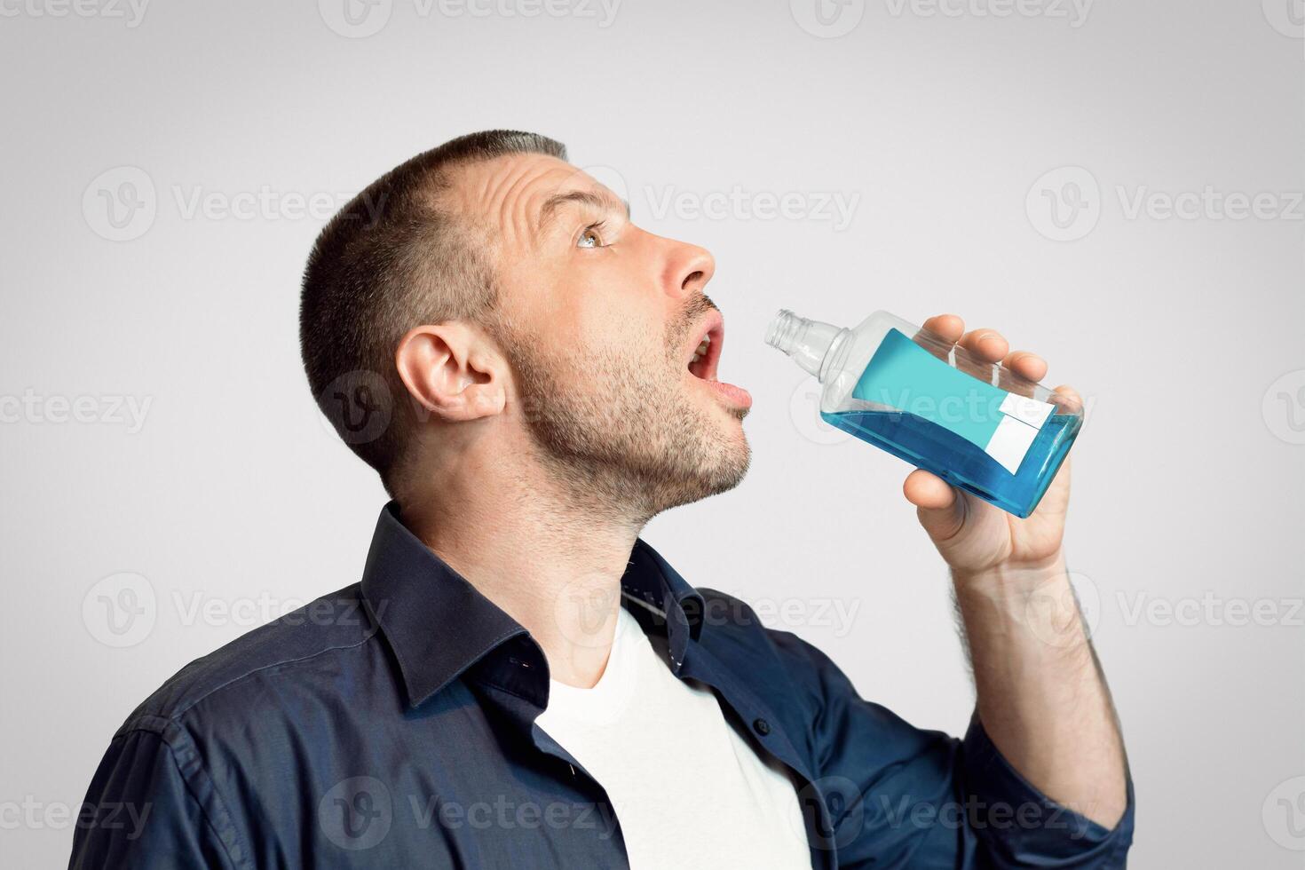 Oral Hygiene. Man Washing Mouth With Oral Rinse Standing Over Gray Background. Panorama photo