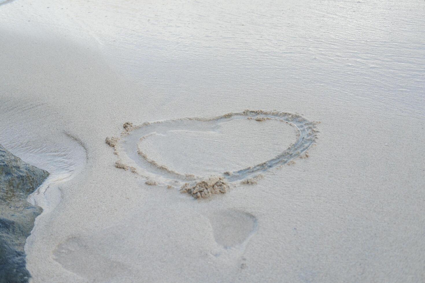 Heart drawn on the beach sand photo