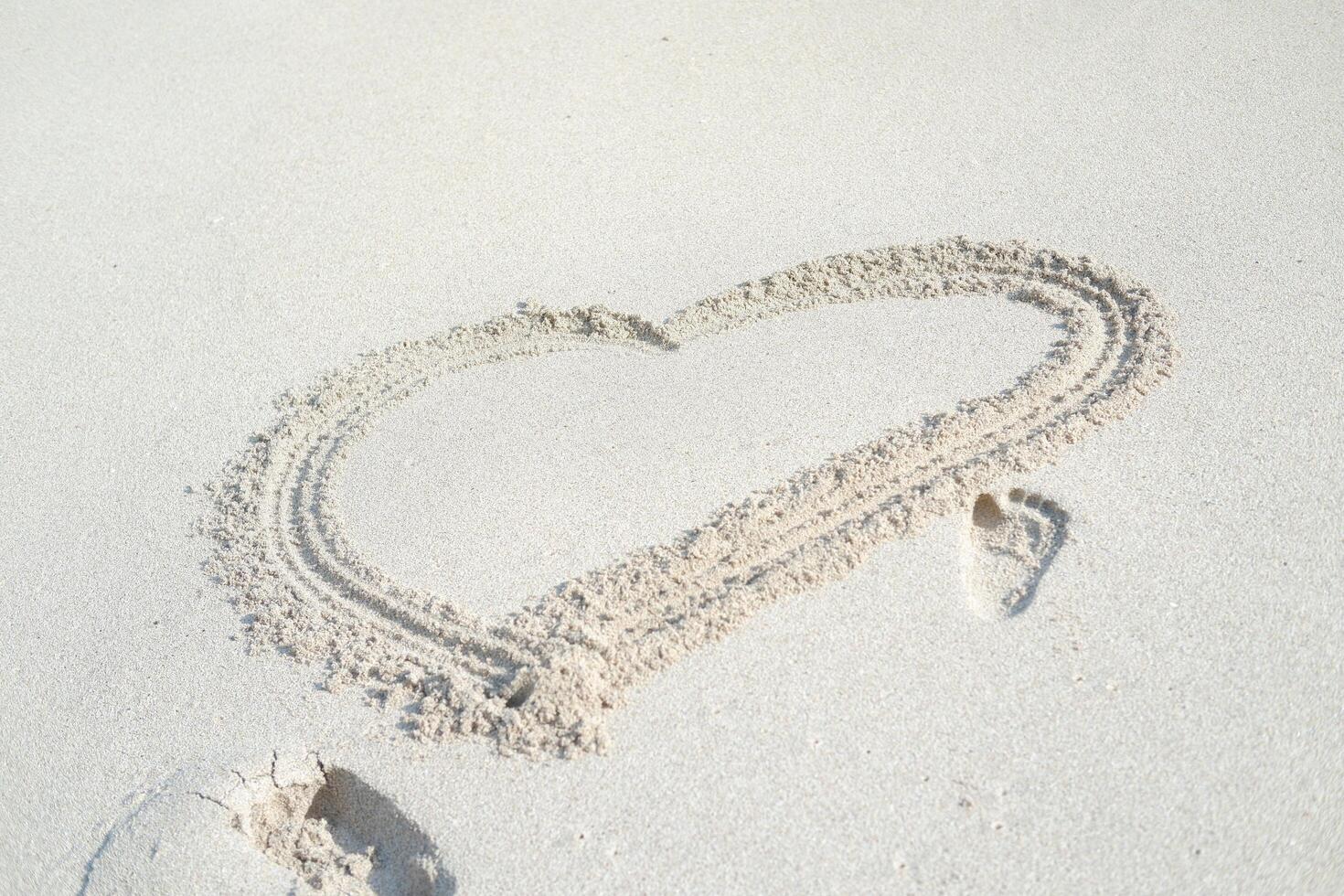 Heart drawn on the beach sand photo
