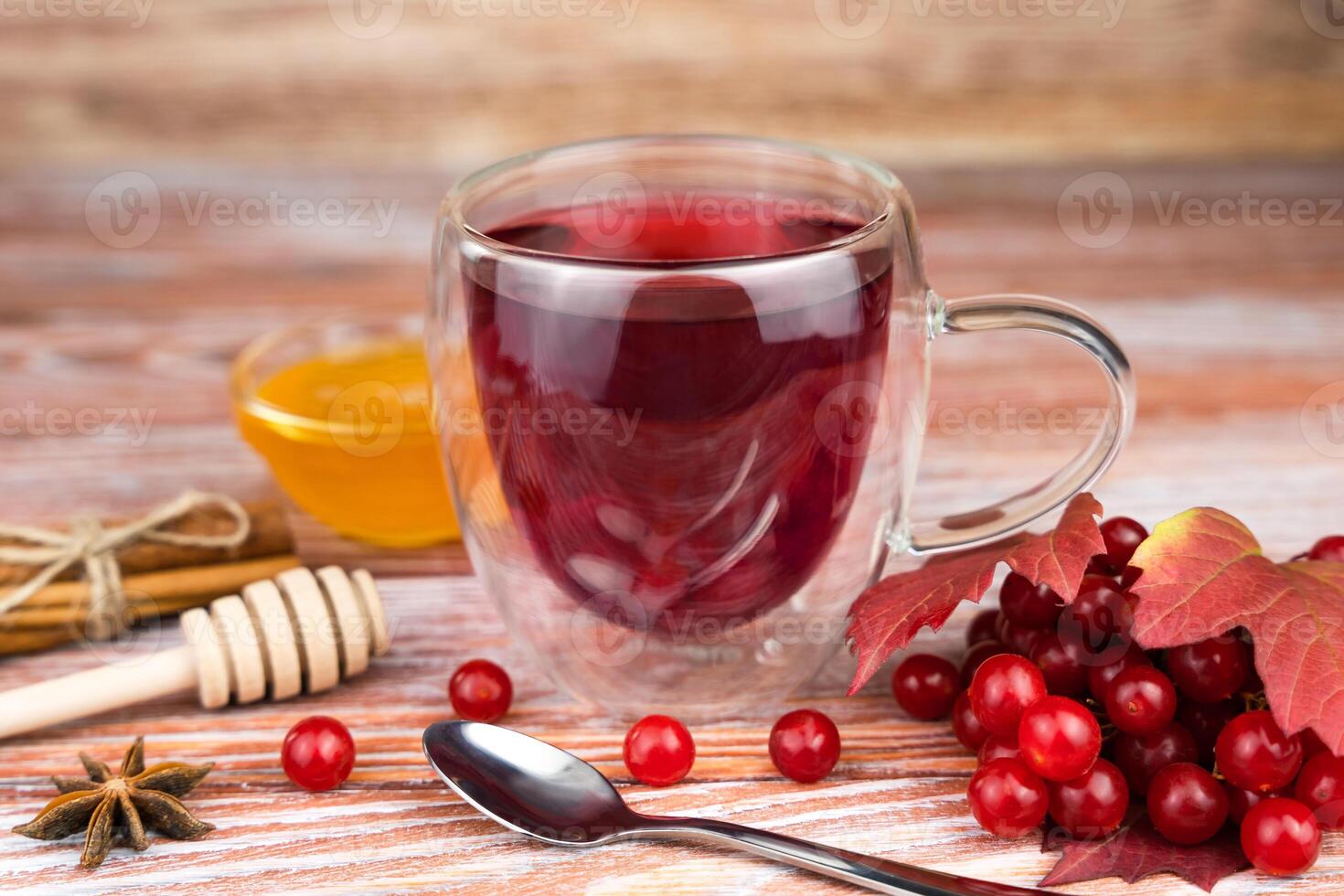 Healthy tea from viburnum with honey on a wooden table. Seasonal vitamin drink. Close-up. Selective focus. photo