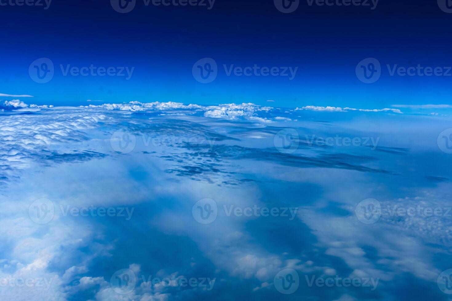 Aerial view from airplane window above green ground. View from the airplane window with beautiful clouds at sunrise. Earth and sky as seen through window of an airplane. photo