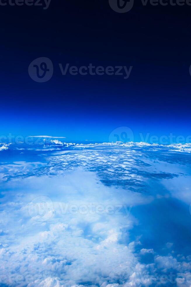 Aerial view from airplane window above green ground. View from the airplane window with beautiful clouds at sunrise. Earth and sky as seen through window of an airplane. photo