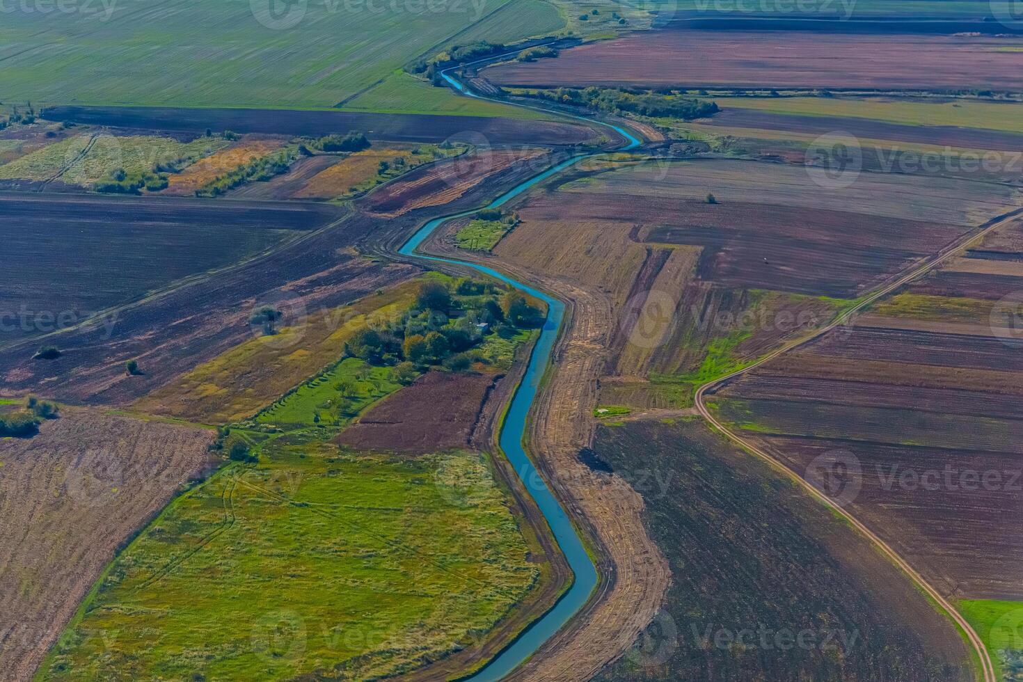 Aerial view of valley with farm fields, pond and Danube river. High quality photo