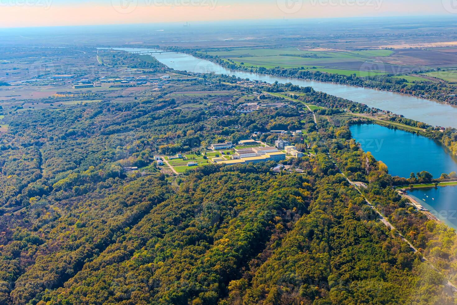 Aerial view of valley with farm fields, pond and Danube river. High quality photo