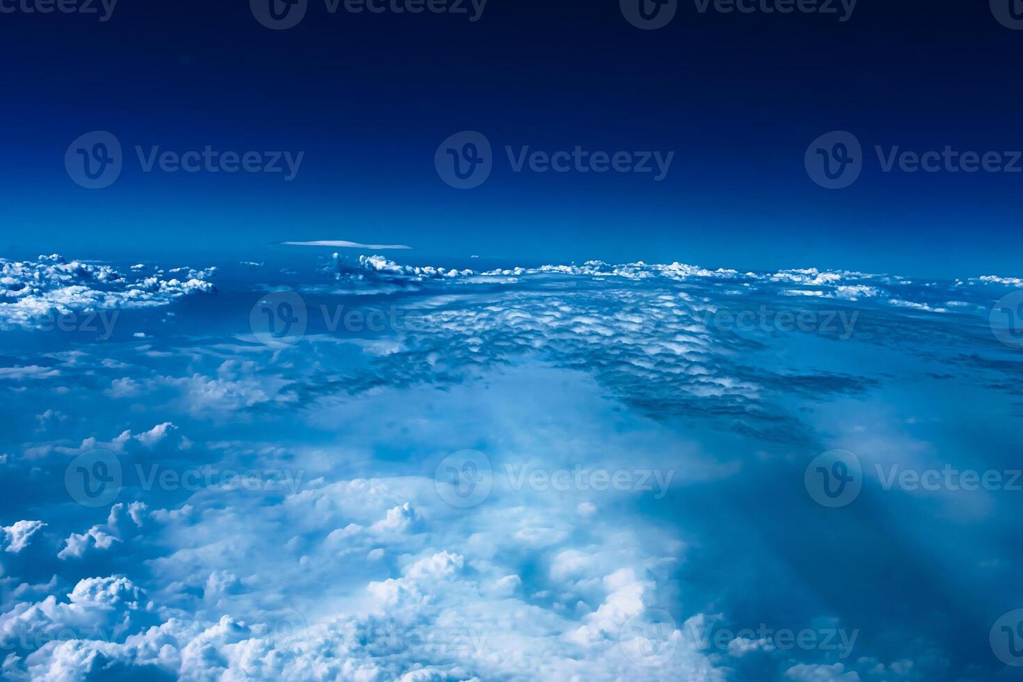 Aerial view from airplane window above green ground. View from the airplane window with beautiful clouds at sunrise. Earth and sky as seen through window of an airplane. photo