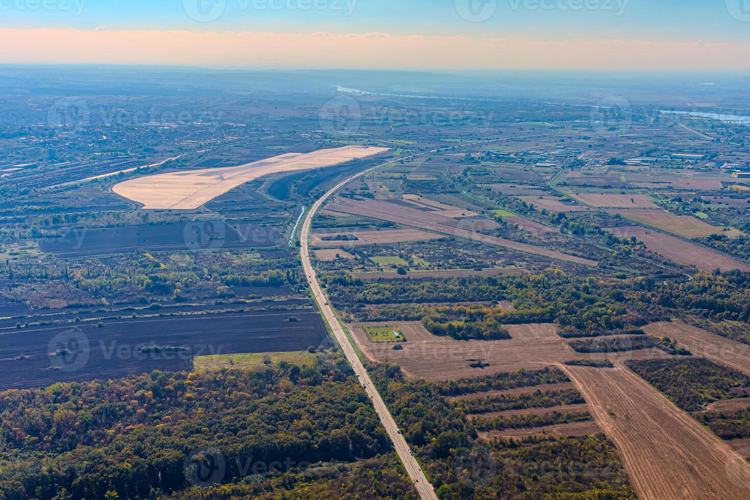 Aerial view of valley with farm fields, pond and Danube river. High quality photo
