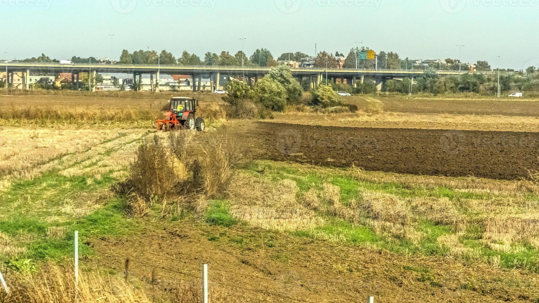 Agricultural fields with young green shoots of grain crops and plowed field without sowing. With trees in the background on the hills. Fallow concept. Alternation. photo