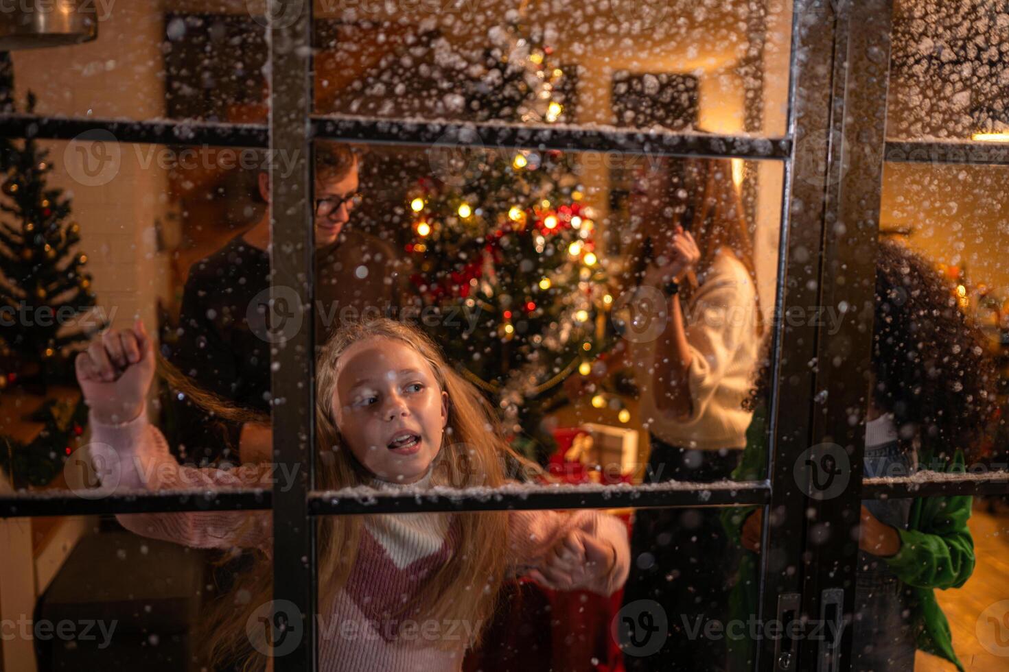 Parents and a teen girl dancing happily on Christmas night with the first snowfall photo