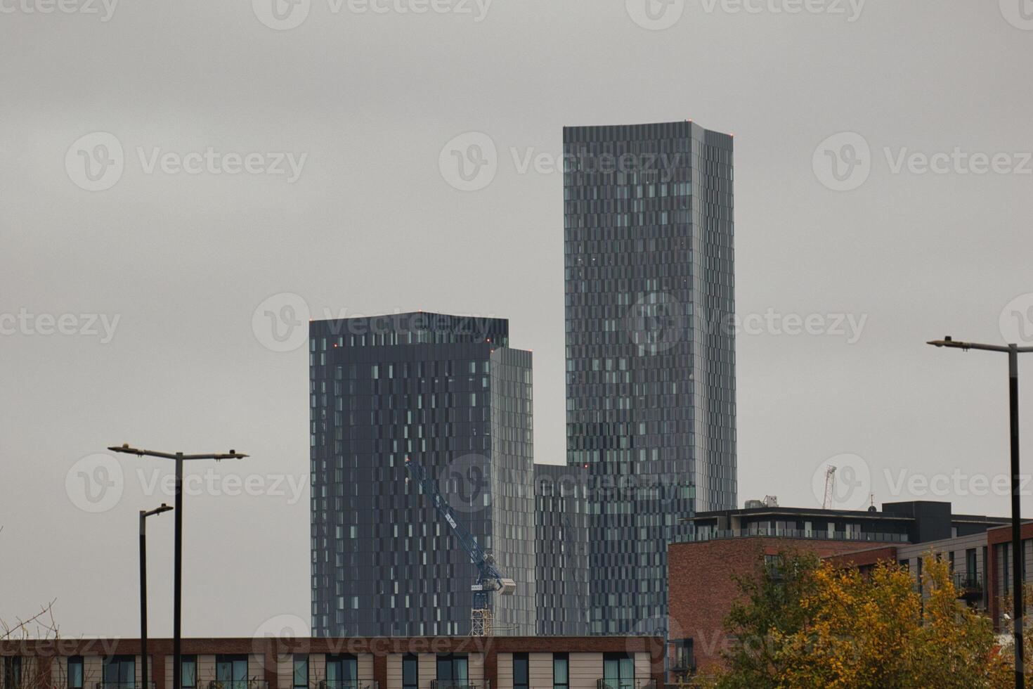 Three Grey Buildings Against a Hazy Sky in Manchester photo