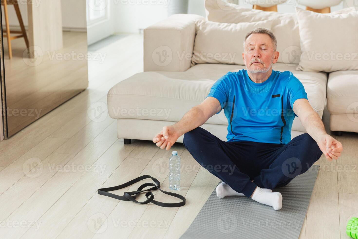 Yoga mindfulness meditation. Senior adult mature man practicing yoga at home. Mid age old grandfather sitting in lotus pose on yoga mat meditating relaxing. Older man doing breathing practice photo