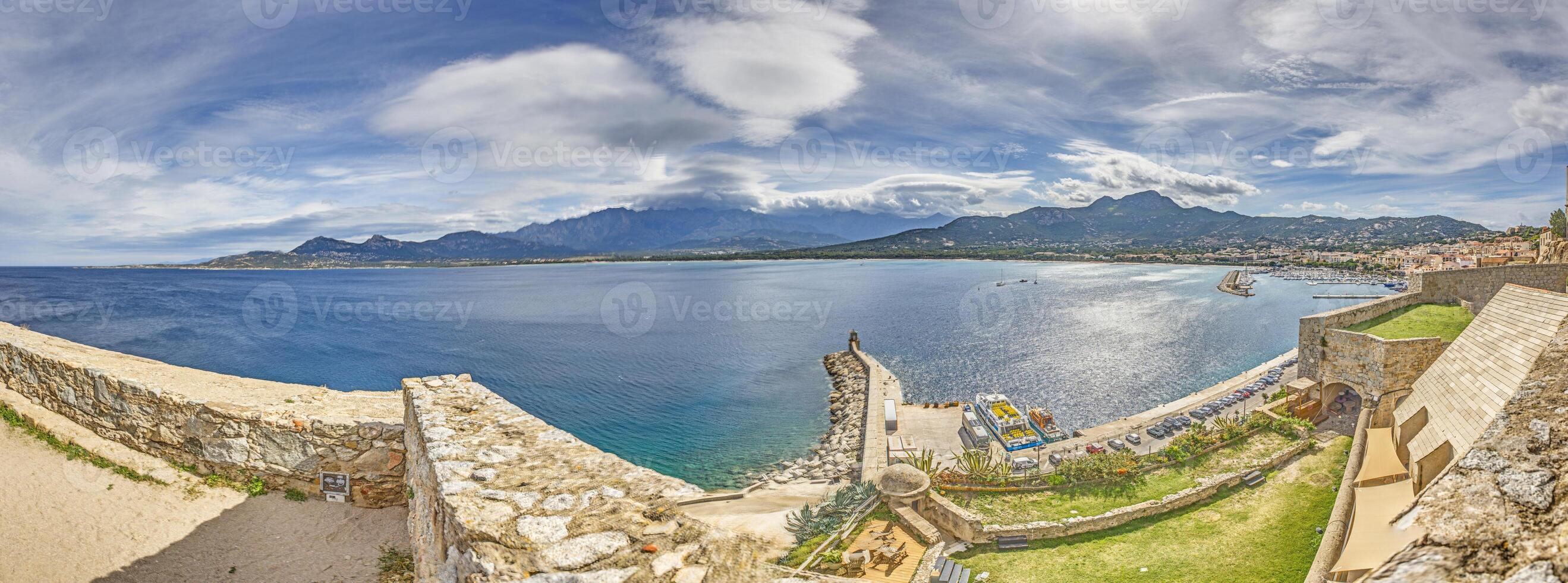 View from the fortress of Calvi in Corsica overlooking the coastline and the sea with mountains photo