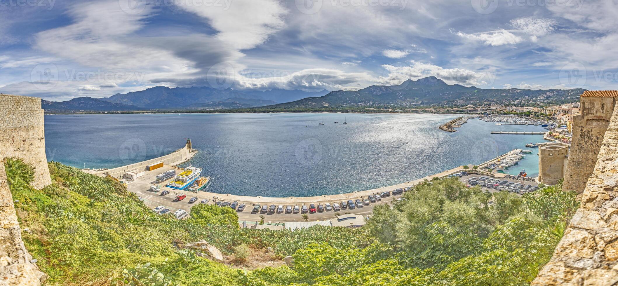 View from the fortress of Calvi in Corsica overlooking the coastline and the sea with mountains photo