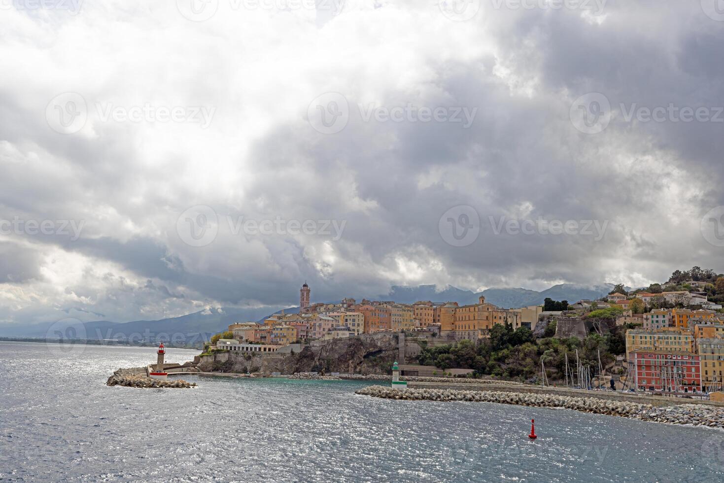 Panoramic view of Bastia Corsica from the sea with colorful buildings under dramatic cloudy skies photo
