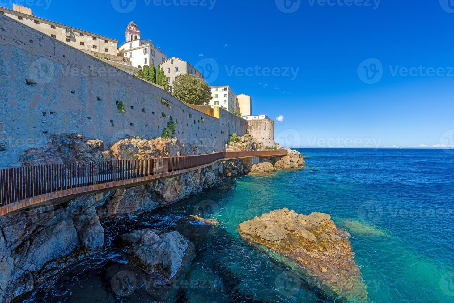 Scenic view of Bastia harbor and historic promenade with colorful buildings under a clear blue sky photo