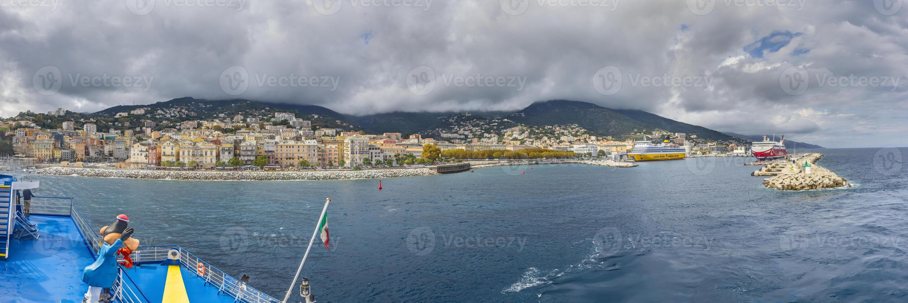Panoramic view of Bastia Corsica from the sea with colorful buildings under dramatic cloudy skies photo