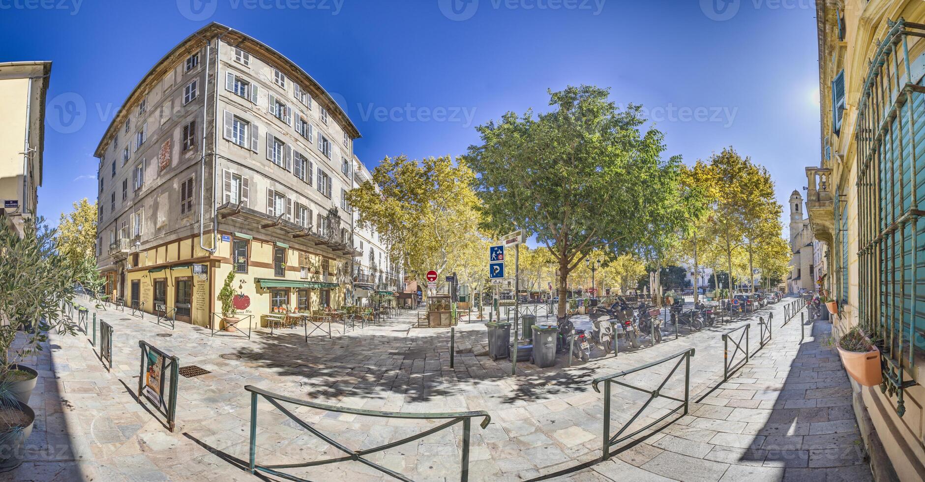 Historic square in Bastia's old town, Corsica, surrounded by buildings and trees under a blue sky photo