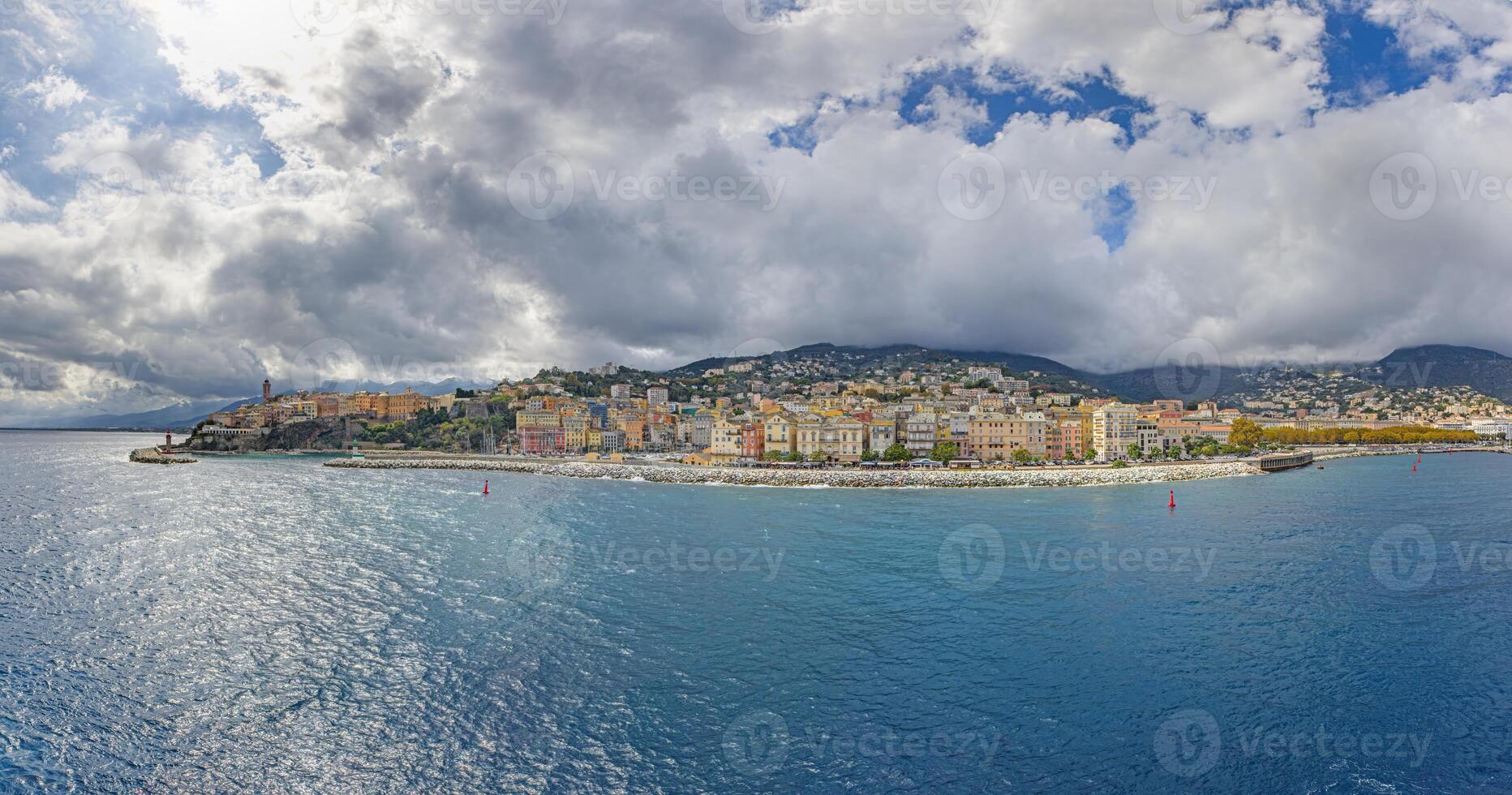 Panoramic view of Bastia Corsica from the sea with colorful buildings under dramatic cloudy skies photo