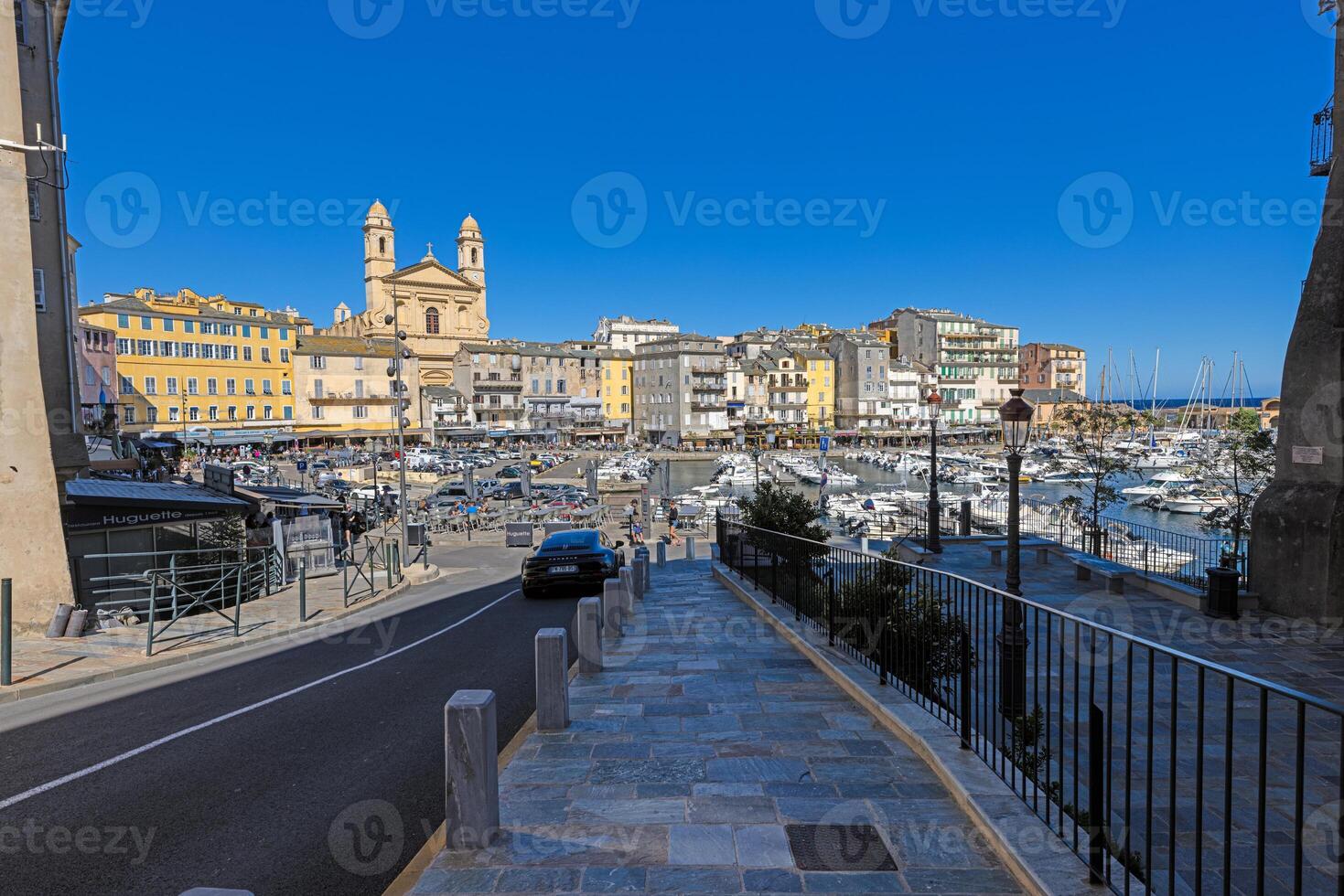 Scenic view of Bastia harbor and historic promenade with colorful buildings under a clear blue sky photo