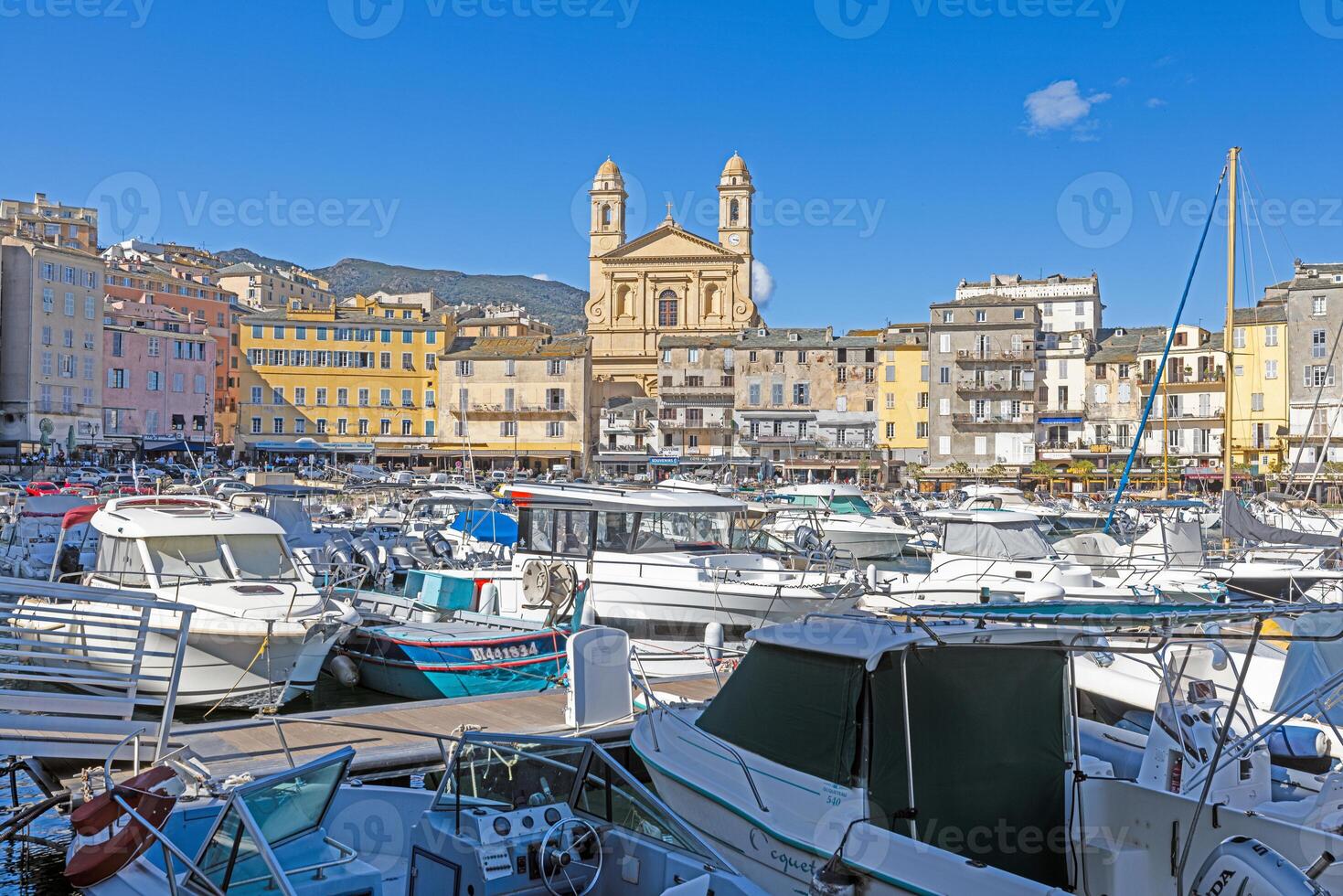 Scenic view of Bastia harbor and historic promenade with colorful buildings under a clear blue sky photo