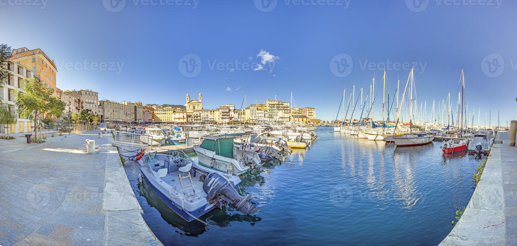 Scenic view of Bastia harbor and historic promenade with colorful buildings under a clear blue sky photo